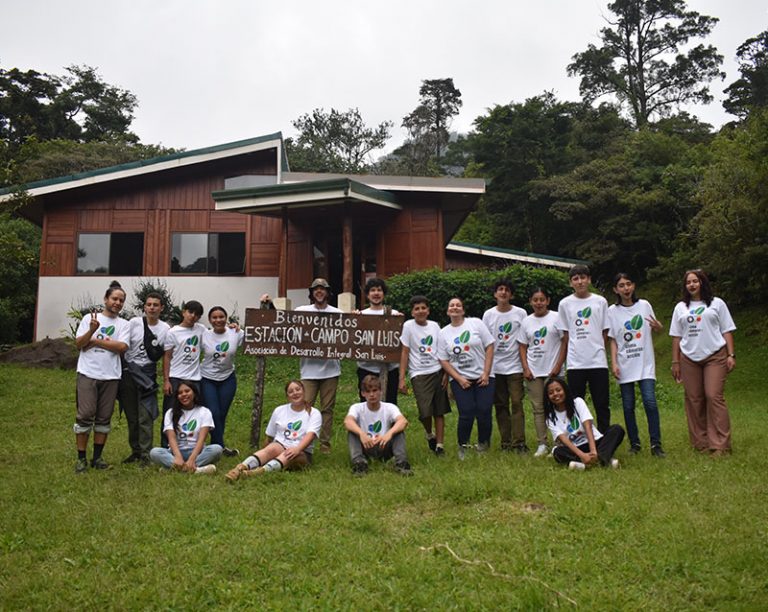 Grupo de jóvenes en posando junto al rótulo de Estación de campo San Luis