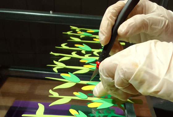 Manos cortando formas de plantas de maíz